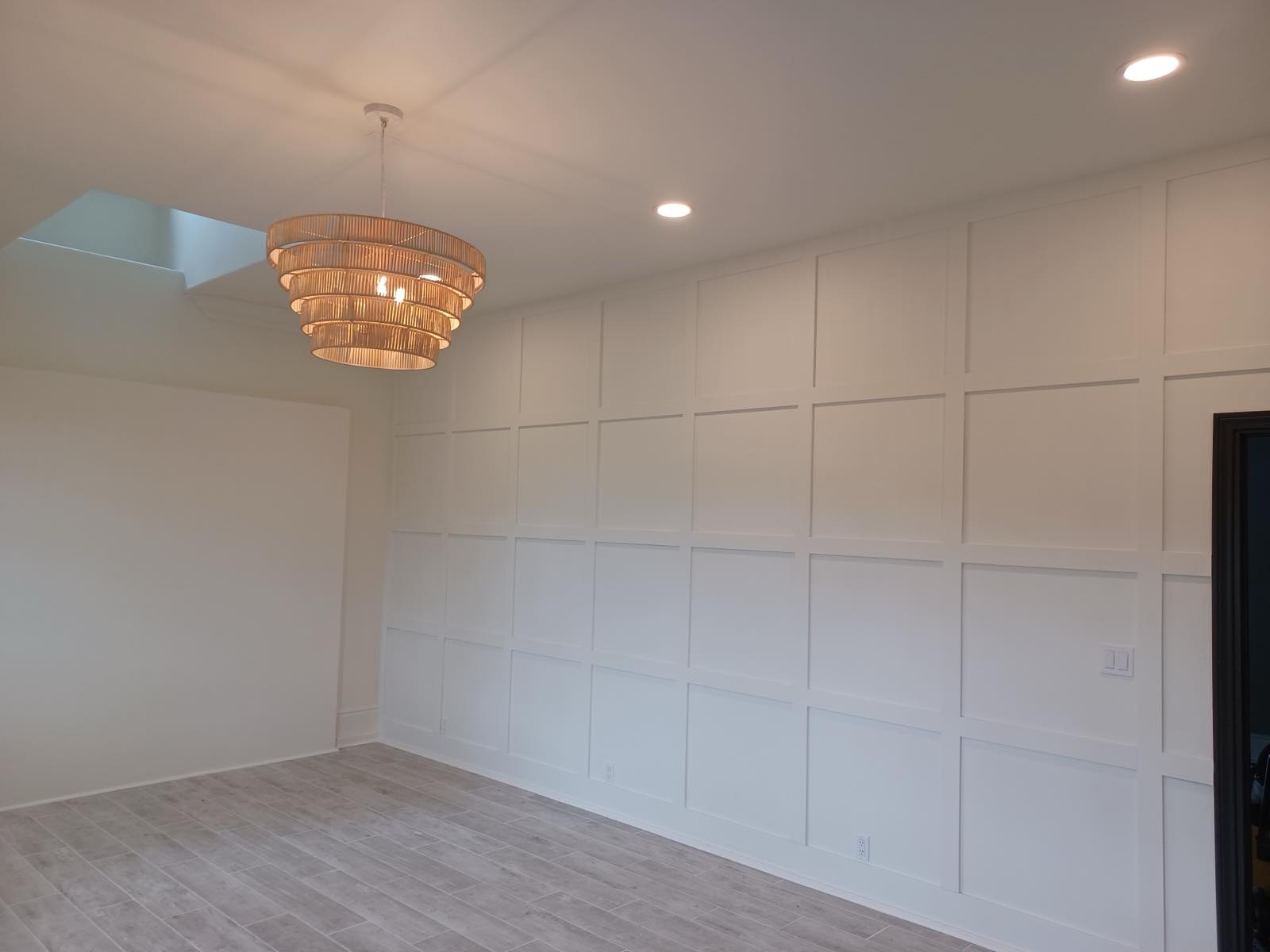 Floor-to-ceiling board and batten accent wall in a dining room with wood-look tile floors